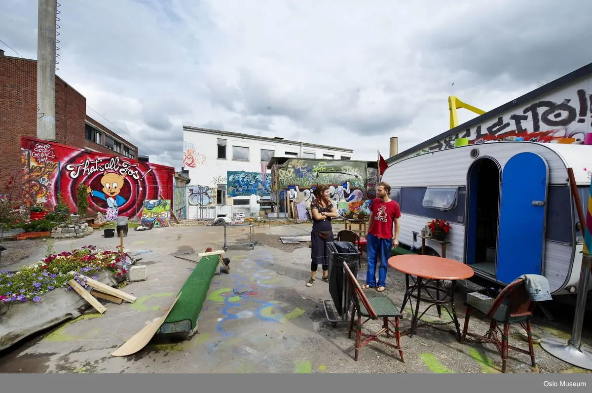 Hausmania, eksteriør, indre gårdsrom, campingvogn, blomster, grønnsaksdyrking, kvinne, mann, bord, stoler.