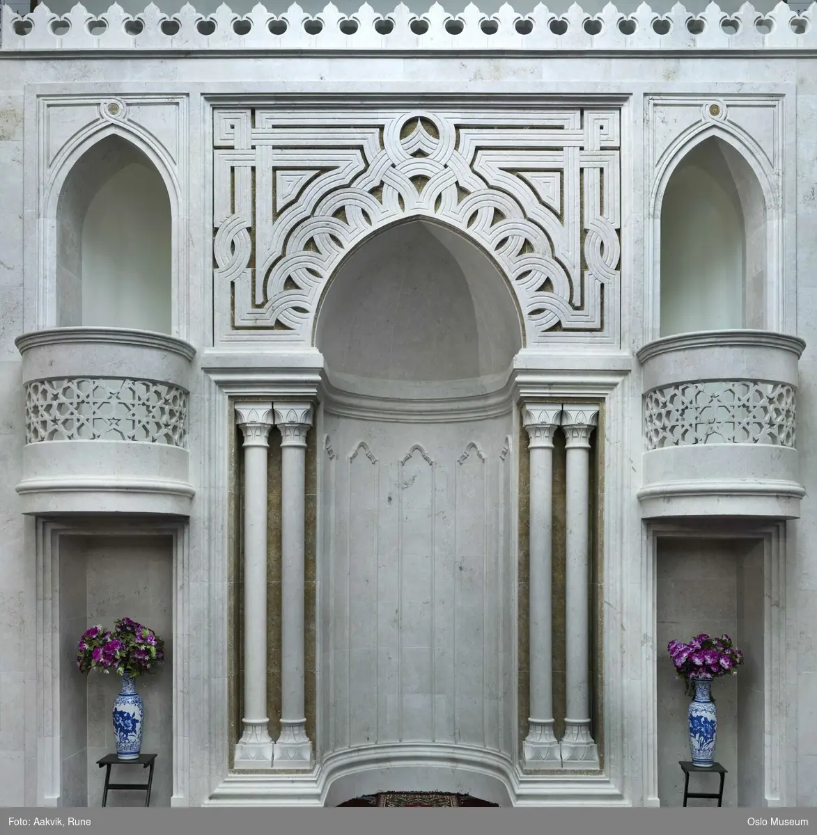 Islam, interiør og symboler fra moskeen Central Jamaat-e Ahl-e Sunnat Norway, Medina, Mekka, koranen, bønn, klokke, lysekrone, qibla, søyler, veggdekorasjon, buer.