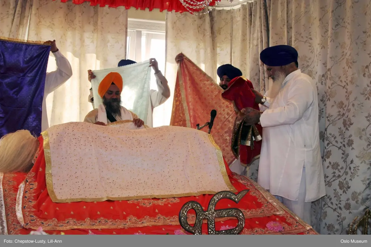 Sikhisme, Gurduara Sri Guru Nanak Dev Ji, sikh tempel, Alnabru i Oslo, interiør, hellig bok, symboler, hellige gjenstander, kvinner, menn, matlaging, bønn, prosesjoner, musikk. 
