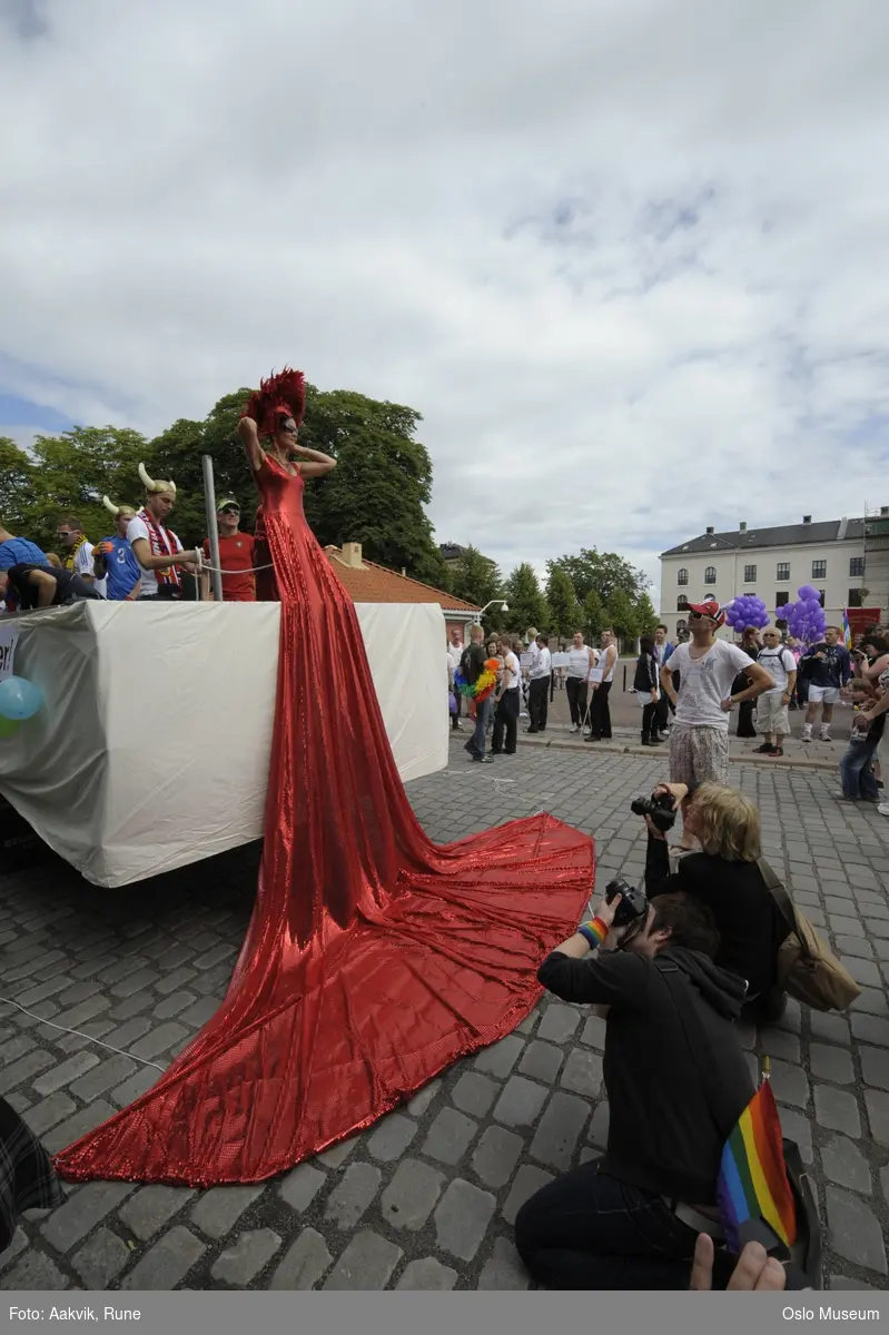 Fotodokumentasjon av Homoparaden 2008. Mennesker, opptog, parade, kostymer, kjøretøy, tilskuere, bannere, paroler, parykker, sminke.