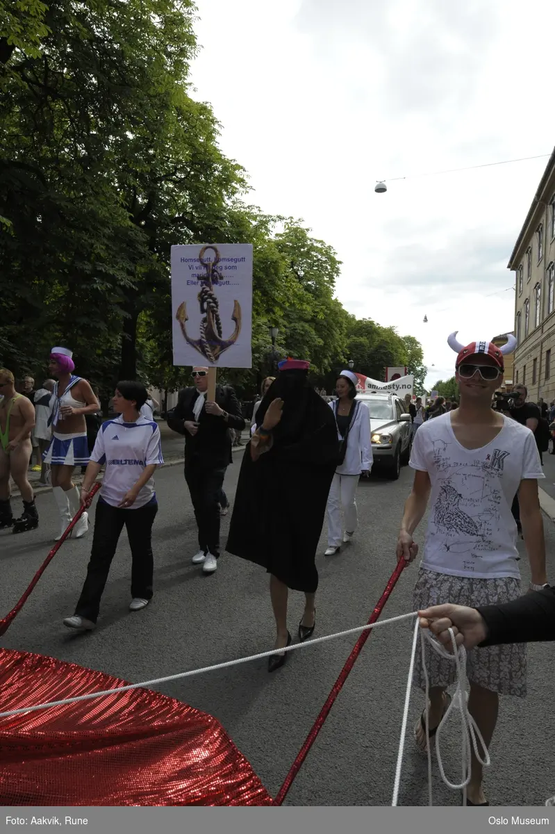 Fotodokumentasjon av Homoparaden 2008. Mennesker, opptog, parade, kostymer, kjøretøy, tilskuere, bannere, paroler, parykker, sminke.