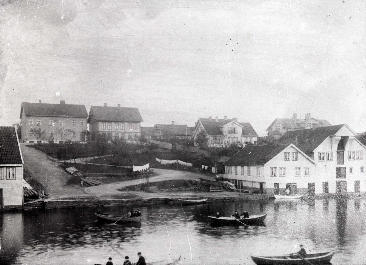 Havn - sjøhus - bymiljø. Vedalmenningen (Nyalmenningen) fotografert fra vest. I forgrunnen flere sjøhus. Bolighus i bakgrunnen.