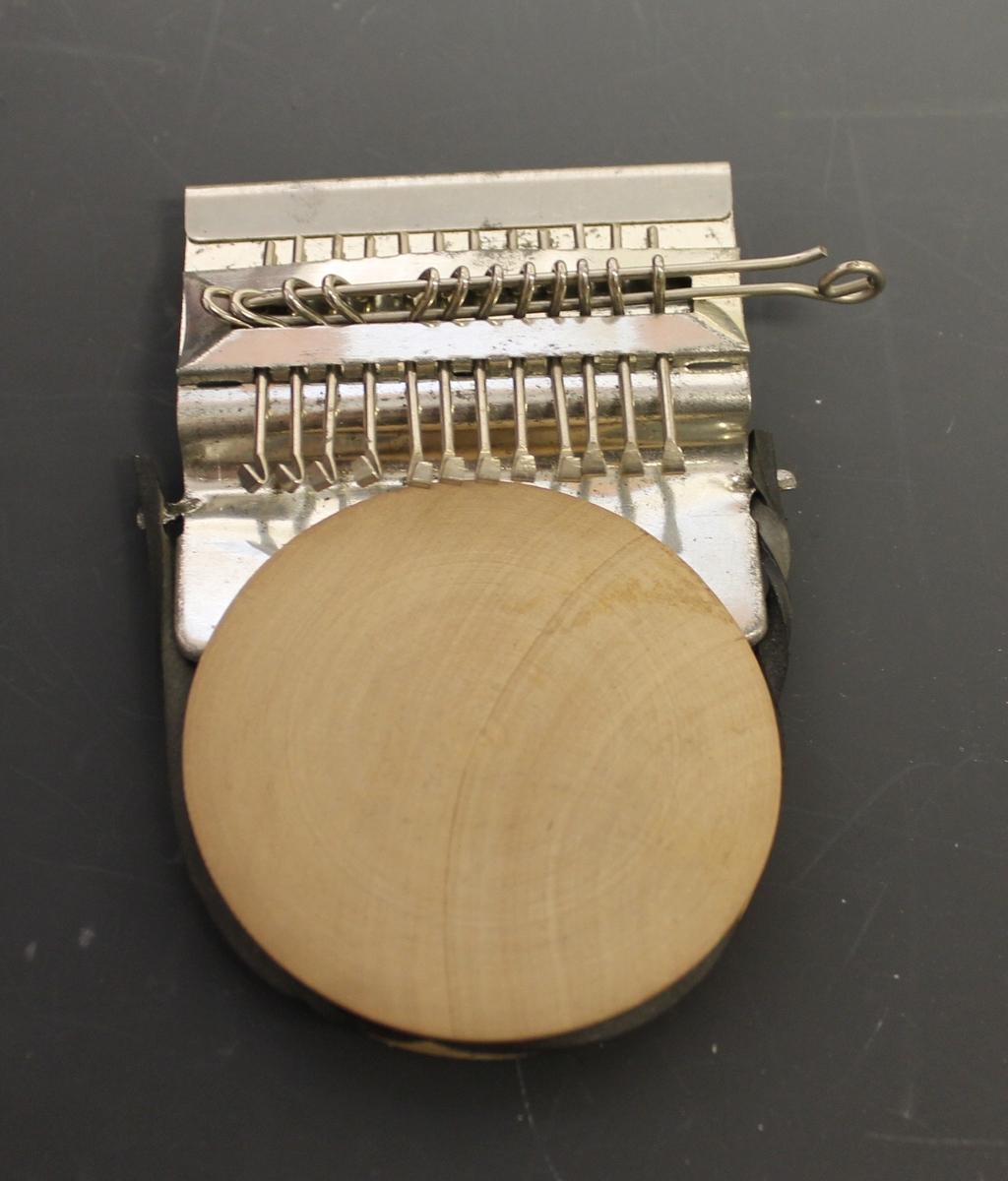 Rektangulær eske med "Stopper'n" og bruksanvisning oppi. brukt til å stoppe hull i strømper, sokker og alle strikket plagg.