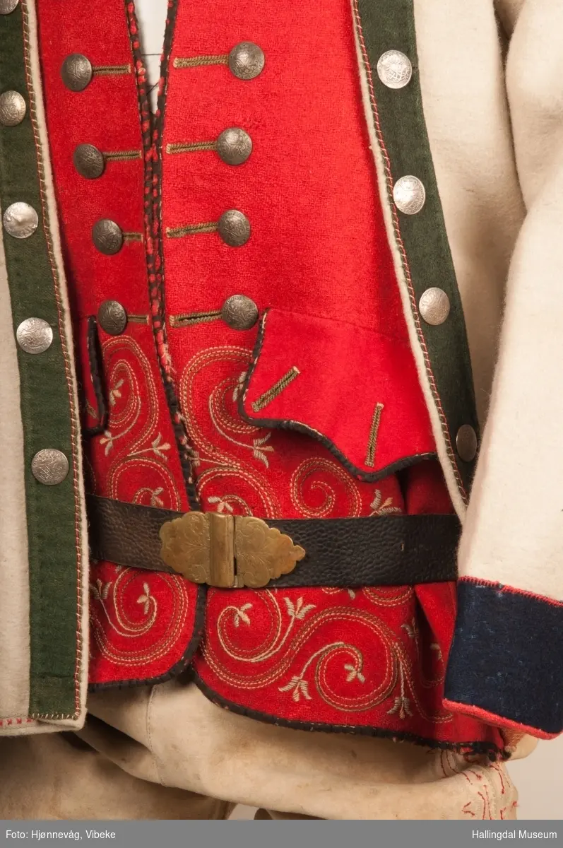 Brudgom fra Hallingdal ca. 1830. Brudgomsdrakten er satt sammen av mange plagg deriblant rød lang rød vest HFN 03616,kvit steglatrøye HFN 03615, høy hatt HFN 03086,  sokkeband HFN 01911 a-b,  knebukse HFN 2024, sko HFN 03124 a-b, skinnbelte HFN 01912, knesokker HFN 03618, kaste 03389 og silkesjal HFN 02004. Brudgommen har stått utstilt i den faste bunadutstillingen på Hallingdal Museum, Nesbyen fra 2009.