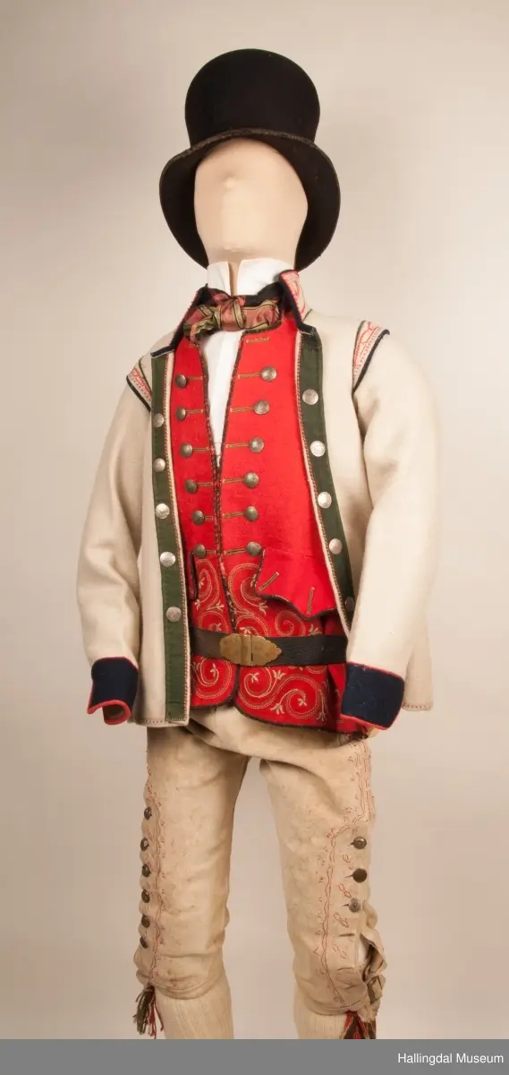 Brudgom fra Hallingdal ca. 1830. Brudgomsdrakten er satt sammen av mange plagg deriblant rød lang rød vest HFN 03616,kvit steglatrøye HFN 03615, høy hatt HFN 03086,  sokkeband HFN 01911 a-b,  knebukse HFN 2024, sko HFN 03124 a-b, skinnbelte HFN 01912, knesokker HFN 03618, kaste 03389 og silkesjal HFN 02004. Brudgommen har stått utstilt i den faste bunadutstillingen på Hallingdal Museum, Nesbyen fra 2009.