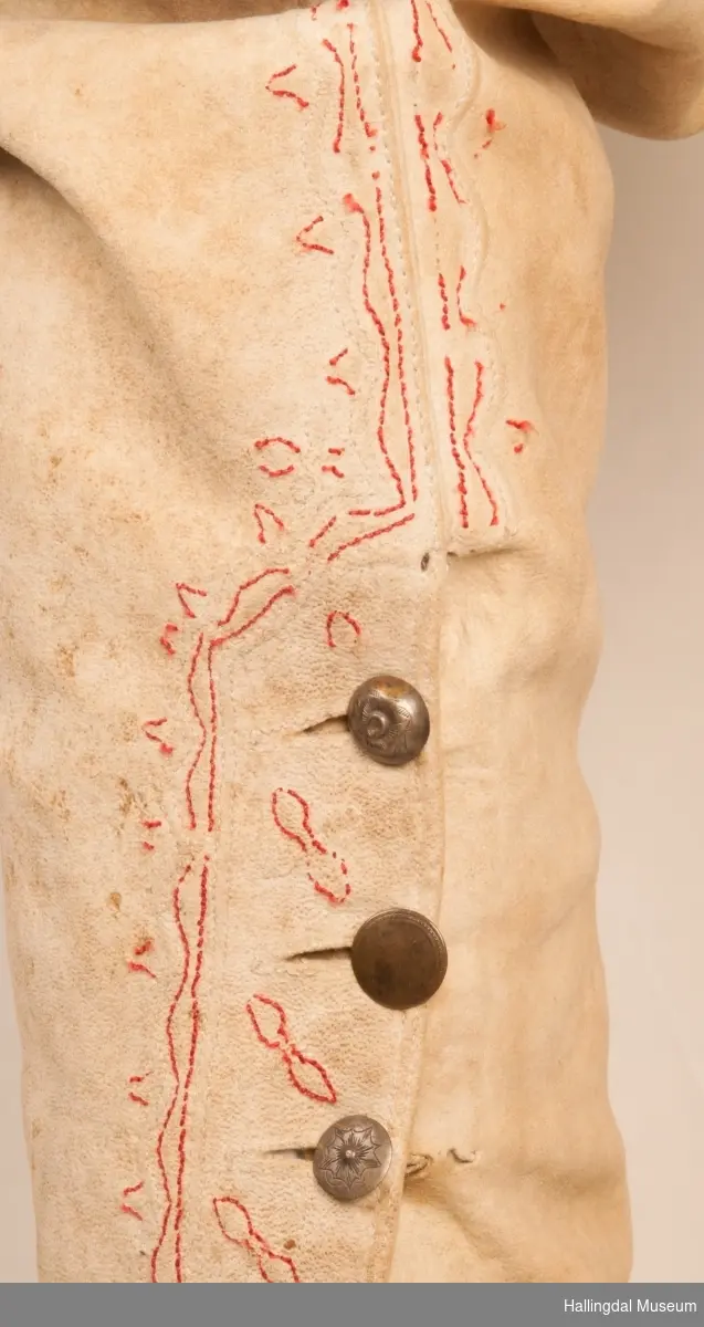 Brudgom fra Hallingdal ca. 1830. Brudgomsdrakten er satt sammen av mange plagg deriblant rød lang rød vest HFN 03616,kvit steglatrøye HFN 03615, høy hatt HFN 03086,  sokkeband HFN 01911 a-b,  knebukse HFN 2024, sko HFN 03124 a-b, skinnbelte HFN 01912, knesokker HFN 03618, kaste 03389 og silkesjal HFN 02004. Brudgommen har stått utstilt i den faste bunadutstillingen på Hallingdal Museum, Nesbyen fra 2009.