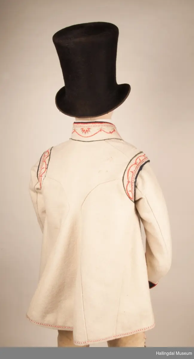 Brudgom fra Hallingdal ca. 1830. Brudgomsdrakten er satt sammen av mange plagg deriblant rød lang rød vest HFN 03616,kvit steglatrøye HFN 03615, høy hatt HFN 03086,  sokkeband HFN 01911 a-b,  knebukse HFN 2024, sko HFN 03124 a-b, skinnbelte HFN 01912, knesokker HFN 03618, kaste 03389 og silkesjal HFN 02004. Brudgommen har stått utstilt i den faste bunadutstillingen på Hallingdal Museum, Nesbyen fra 2009.