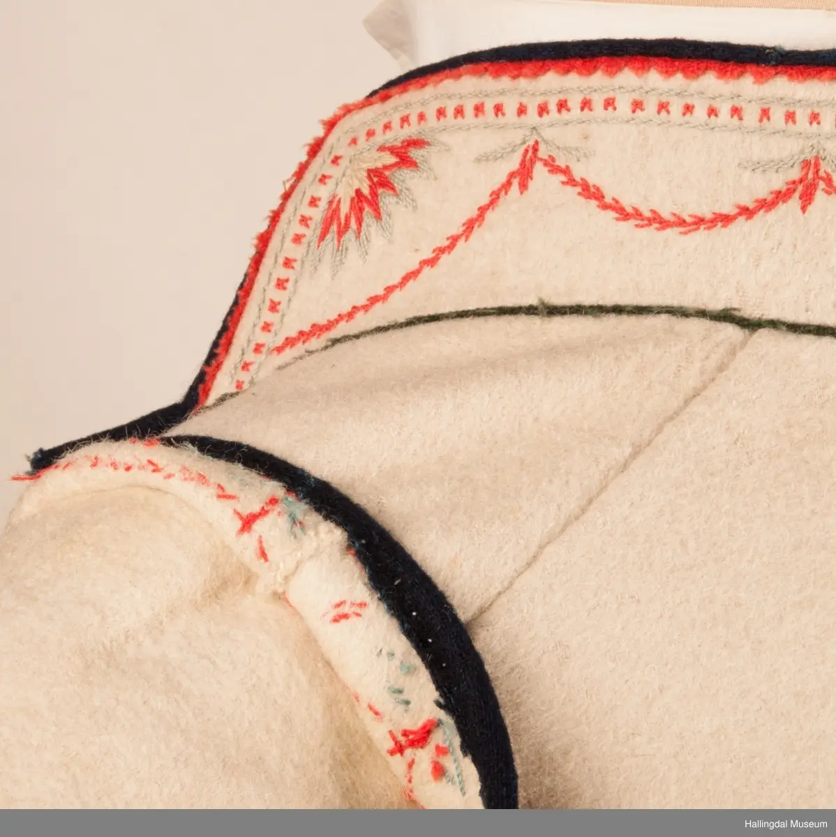 Brudgom fra Hallingdal ca. 1830. Brudgomsdrakten er satt sammen av mange plagg deriblant rød lang rød vest HFN 03616,kvit steglatrøye HFN 03615, høy hatt HFN 03086,  sokkeband HFN 01911 a-b,  knebukse HFN 2024, sko HFN 03124 a-b, skinnbelte HFN 01912, knesokker HFN 03618, kaste 03389 og silkesjal HFN 02004. Brudgommen har stått utstilt i den faste bunadutstillingen på Hallingdal Museum, Nesbyen fra 2009.