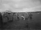 Pressbesök vid flygövningen Västgötamanövern, 1931.
Civila män och militärer samlade framför tälthangarer på ett flygfält.