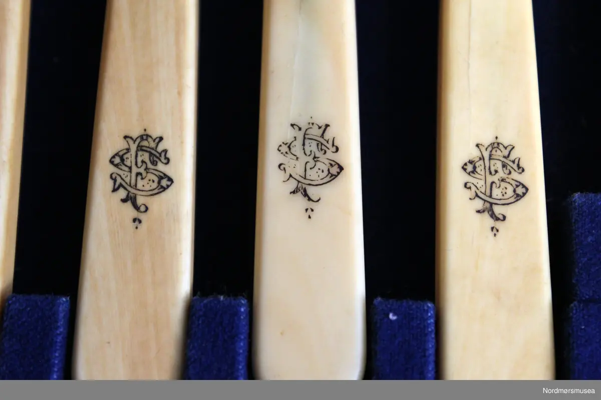 Fiskebestikket består av 12 gafler, 12 kniver. og serveringsbestikk som består av en gaffel og en kniv.
Skaftet består av perlemor med monogram.
Bladet på kniven er dekorert med stiliserte blomster og en fisk.