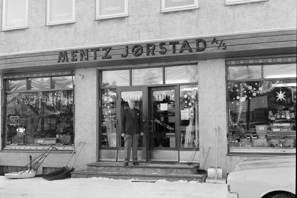Mentz Jørstad AS, Jern og byggevareforretning i Nygata, Brumunddal. 
Juleutstilling, juletre. Bernhard Bjørnstad utenfor forretningen.