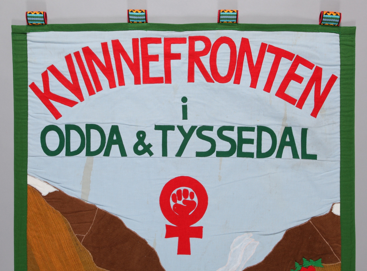 Tre kvinner, handtrykk, fjordlandskap med fabrikkar. Kvinnefronten sin logo; knyttneven i det biologisk teikn for hokjønn. Motiv og tekst kun på framsida. 
Motivet gjev uttrykk for samhald og solidaritet,  viser kvinner i samla flokk framfor Odda og Søfjorden med fjella som bakgrunn.