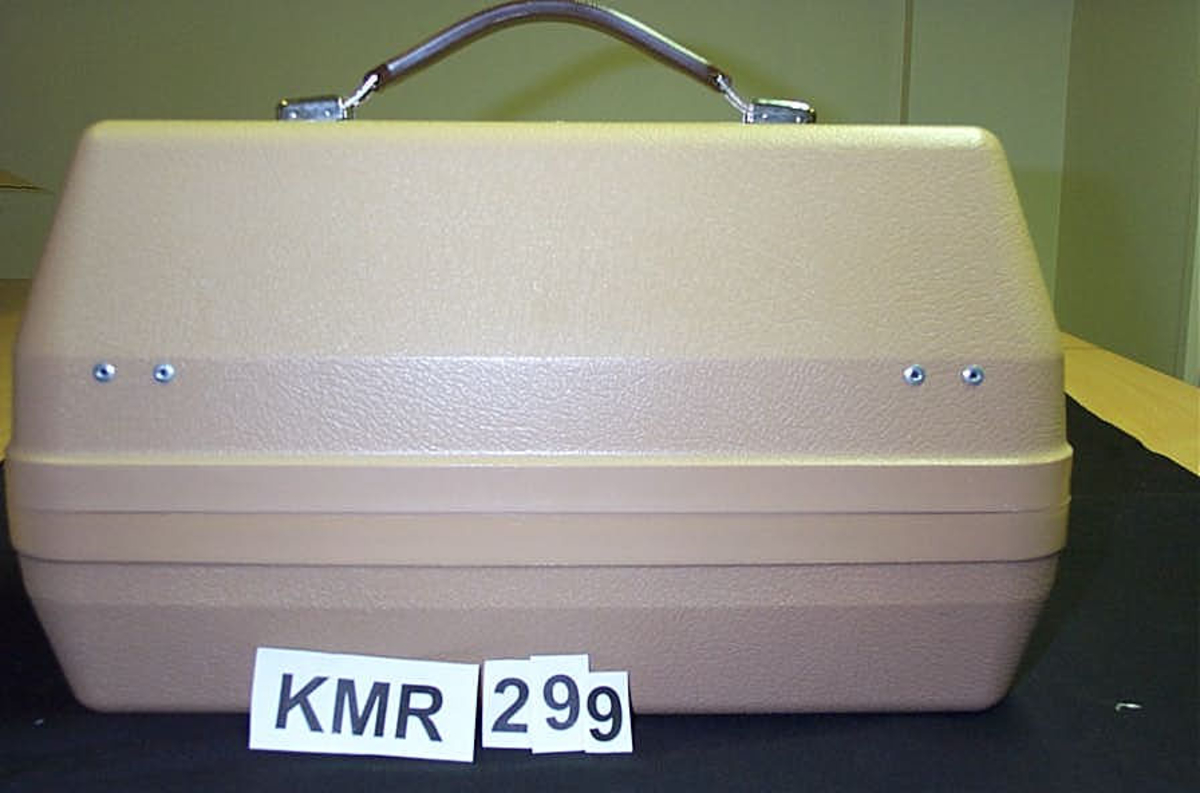 Talemaskin; koffert med utstyr, 9 deler, A hovedapparat, nederste del av kofferten, apparatet har 7 brune skruknotter, hvit ledning, B koffertens lokk som inneholder, C-D mikrofoner, E-F-G- kassetter, H øresett til lytting (høretelefon) I bruksanvisning alle deler pakket i plast