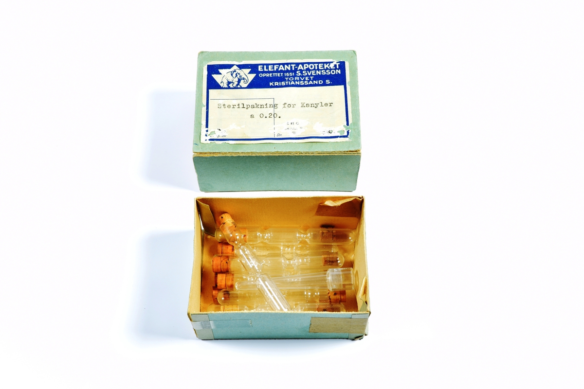 Skrin med lokk i hvit porselen. Skrinet inneholder diverse gjenstander brukt i apotekvirksomhet.

Skrinnet inneholder:

1 grønn eske med "Sterilpakning for kanyler". I esken ligger det 13 små rør i glass og 1 i plast.

1 hvit eske med 8 ampuller med Dolormin til injeksjon.

2 uåpnede pakker med sprøyter, produsert i Tyskland. Eskene er dekorert med et blått kors på en gullfarget bakgrunn og en logo som viser et hus og bostaven H.

2 kvadratiske metallbokser med sprøyter. På lokket til en av boksene er det en logo som viser et hus og bokstaven H.

1 pose med seks munnstykker til nesespylere.

1 lite knivblad med tager og bokstavene A L.

1 pose med flere små stålrør med et lite dråpeformet "håndtak" i en ende.

1 liten pumpe i rød gummi.