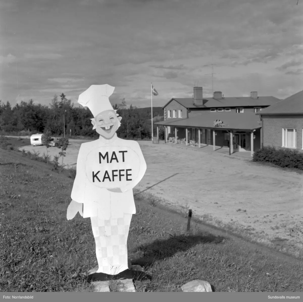 Skyltning utefter vägen mellan Sundsvall och hälsingegränsen 1961. Bland annat Bergafjärden, Dingersjö, Bredsand och Kusten. I Njurundabommen fick länge trafikanterna söderifrån lätta på gasen och anamma ett makligare tempo. Men innan vägen som nu blivit ”gamla E4:an” byggdes, var det så här som korsningen i Bommen såg ut. Längst till höger i bild skymtar det före detta bankhuset som fortfarande finns kvar.