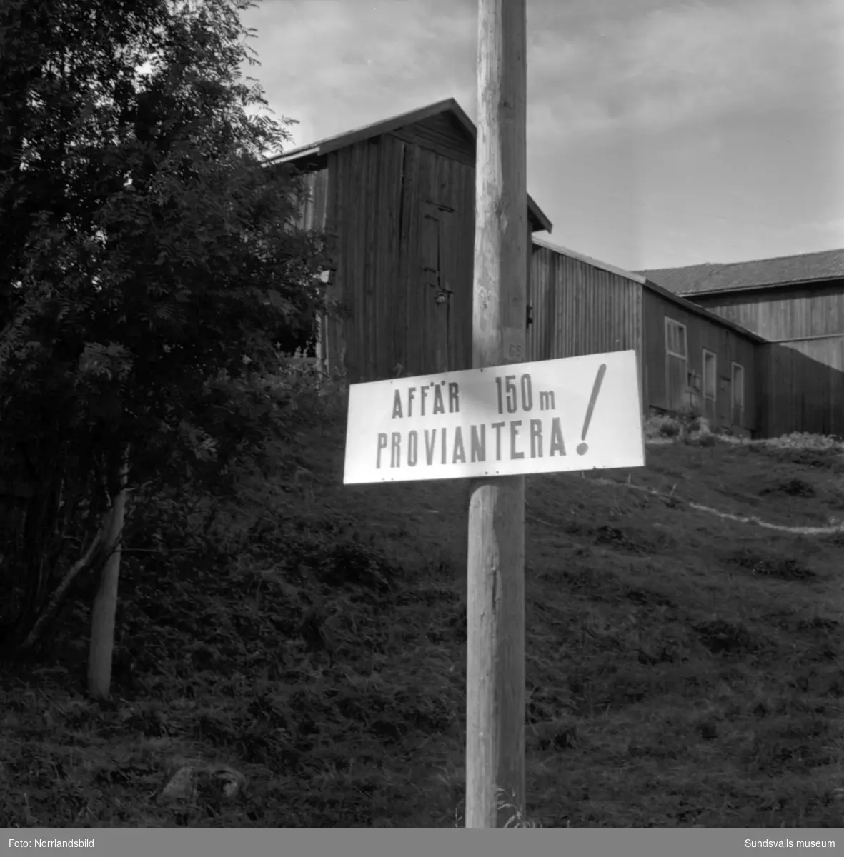 Skyltning utefter vägen mellan Sundsvall och hälsingegränsen 1961. Bland annat Bergafjärden, Dingersjö, Bredsand och Kusten. I Njurundabommen fick länge trafikanterna söderifrån lätta på gasen och anamma ett makligare tempo. Men innan vägen som nu blivit ”gamla E4:an” byggdes, var det så här som korsningen i Bommen såg ut. Längst till höger i bild skymtar det före detta bankhuset som fortfarande finns kvar.