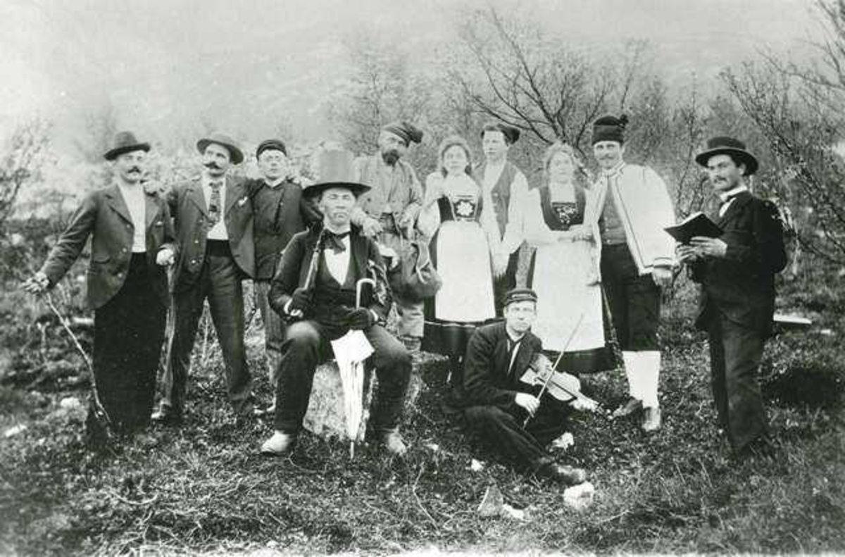 Aktørene i skuespillet "Til sæters" oppført på "Skarpen".  Fra v.: Johan Berg, Andreassen, Einar Wexelsen, E. Holst, J. P. Olsen, frk Berg, Albert Lauring, Synnøve Hjortsæther (g.m. Lauring), Olaf Jarl Roller, maler. Med fiolinen Johannes Olsen (Soløy. 