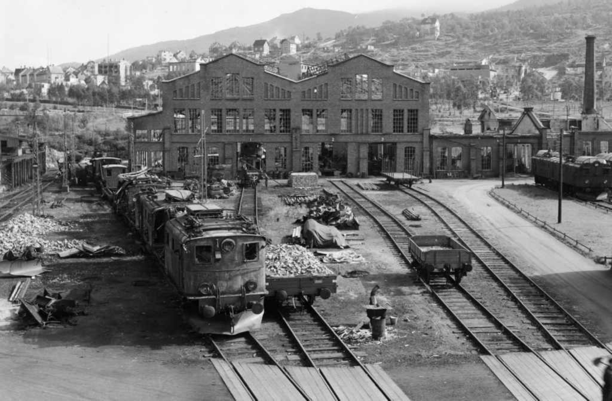 Verkstedtomta - NSBs verksted og lokomotiv krigsskadet 1940 Narvik, Ofotbanen. Opprydding. Loket til høyre var et elektrisk lokomotiv av type El.3 og loket til venstre var et elektrisk lokomtiv av type El.4.