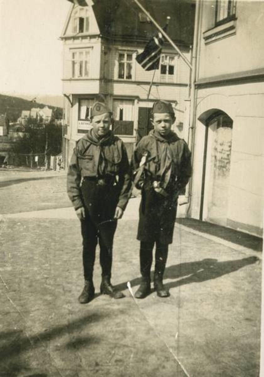 Fra v, Leif Lind og en annen spedergutt. To Ofotens Tidende bygget bak. Til høyre. Iversengården hvor fotograf Lind holdt til bak.