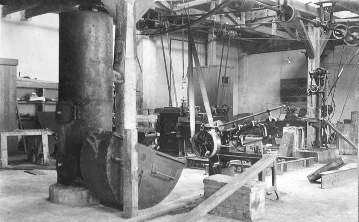 Inne i det mekaniske verkstedet til fabrikken. Den runde ovnen til venstre var kullfyrt og brukt til oppvarming.