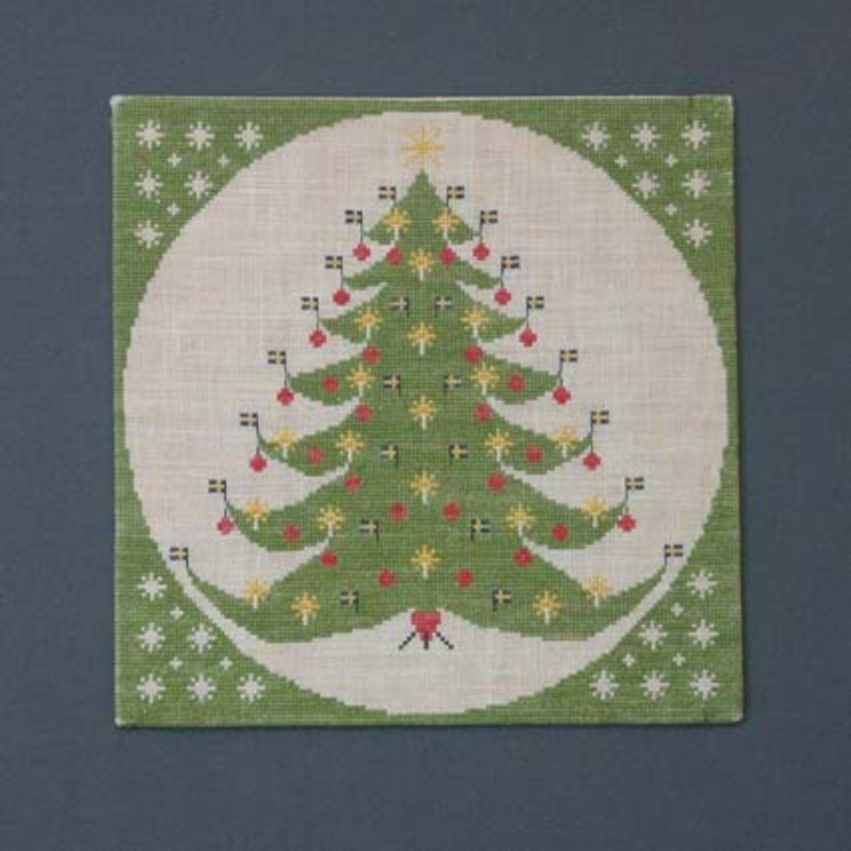 Julbonad med korsstygnsbroderi på linneväv. Bonaden tillhör Runda serien som är en serie julbonader formgivna av Irma Kronlund, en bonad per år från 1971 till 1989.
