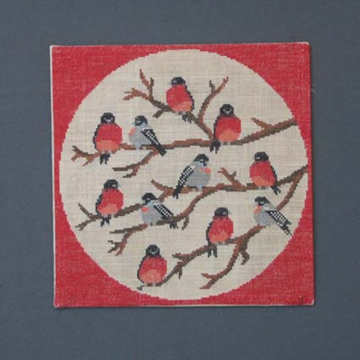Julbonad med korsstygnsbroderi på linneväv. Bonaden tillhör Runda serien som är en serie julbonader formgivna av Irma Kronlund, en bonad per år från 1971 till 1989.