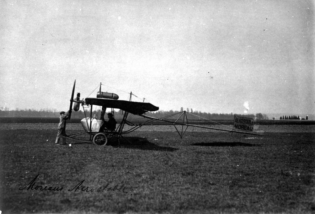 Ett fly på bakken, Moreau. To personer, menn, ved flyet.