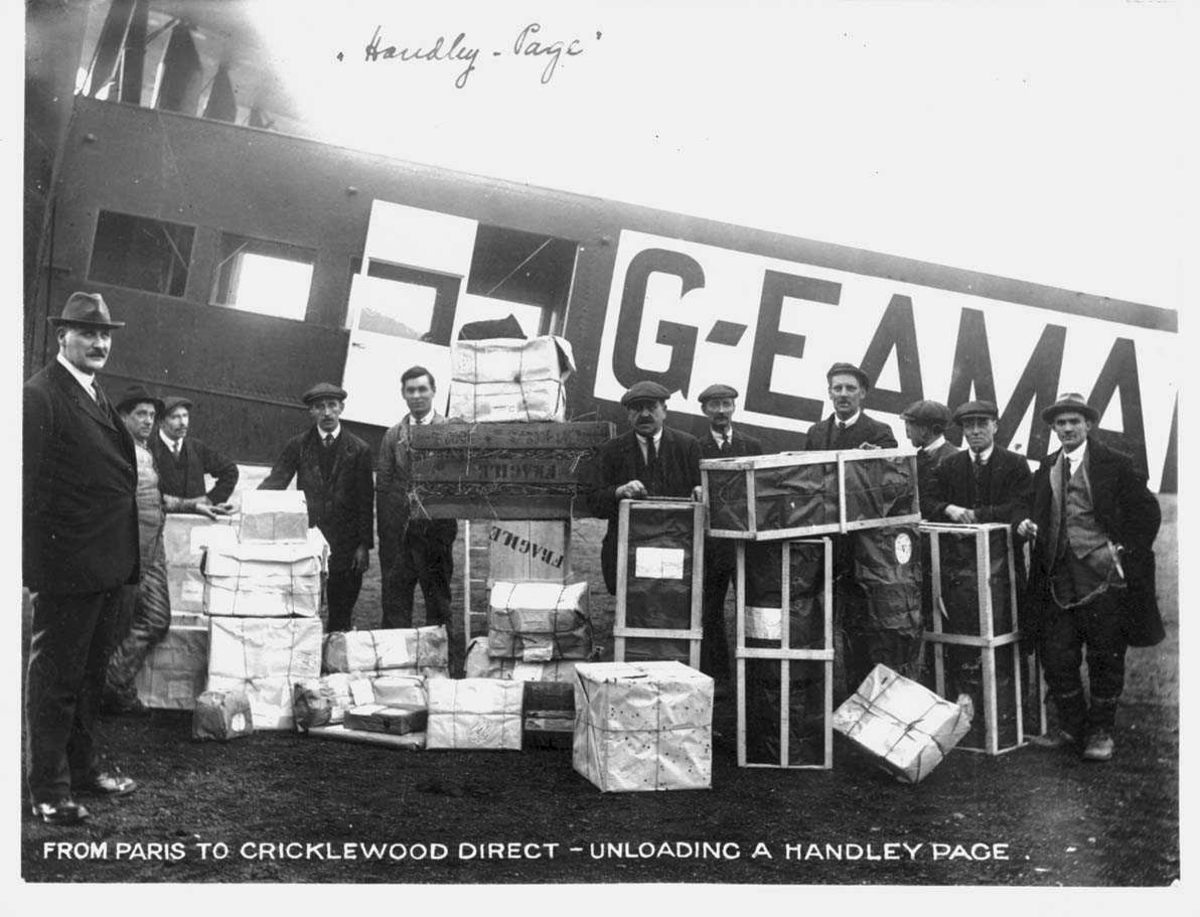 Ett fly på bakken, Handley Page 0/400. G-EAMA. 11 personer ved fly, rundt bagasje. 