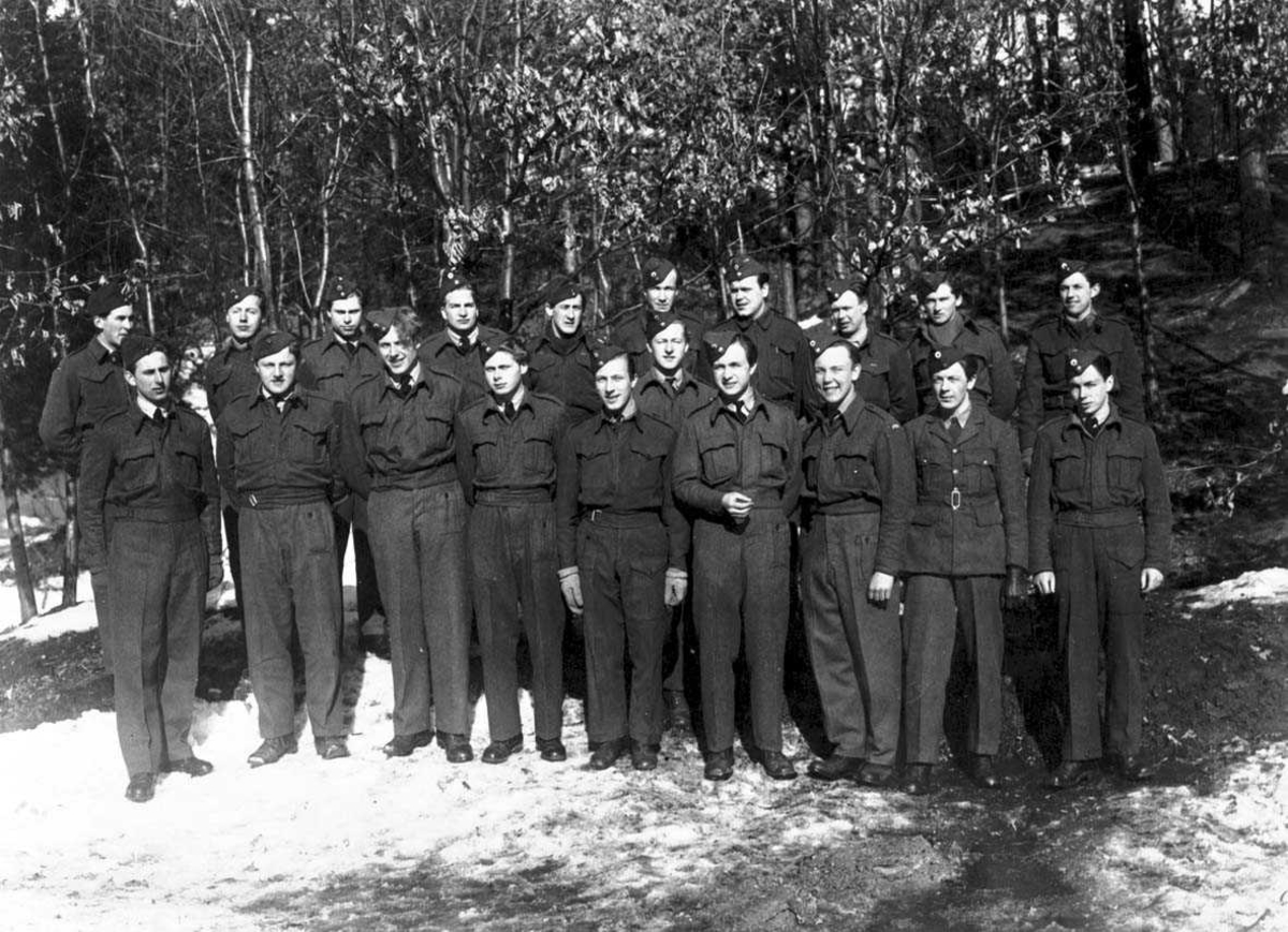 Gruppebilde. Flere personer, menn i militæruniform oppstilt utendørs.
