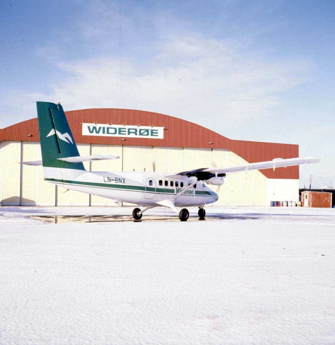 Lufthavn/Flyplass. Bodø. Ett fly, LN-BNX DHC-6-300 Twin Otter fra Widerøe, parkert utenfor Widerøes hangar.