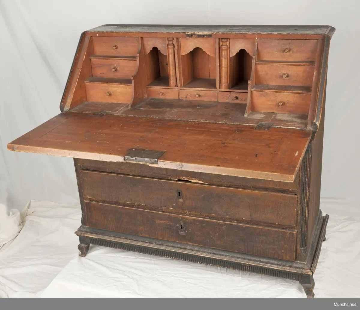 Et skatoll med 4 skuffer og sarg.  To speil i klaffen ni små skuffer inni og tre rom.