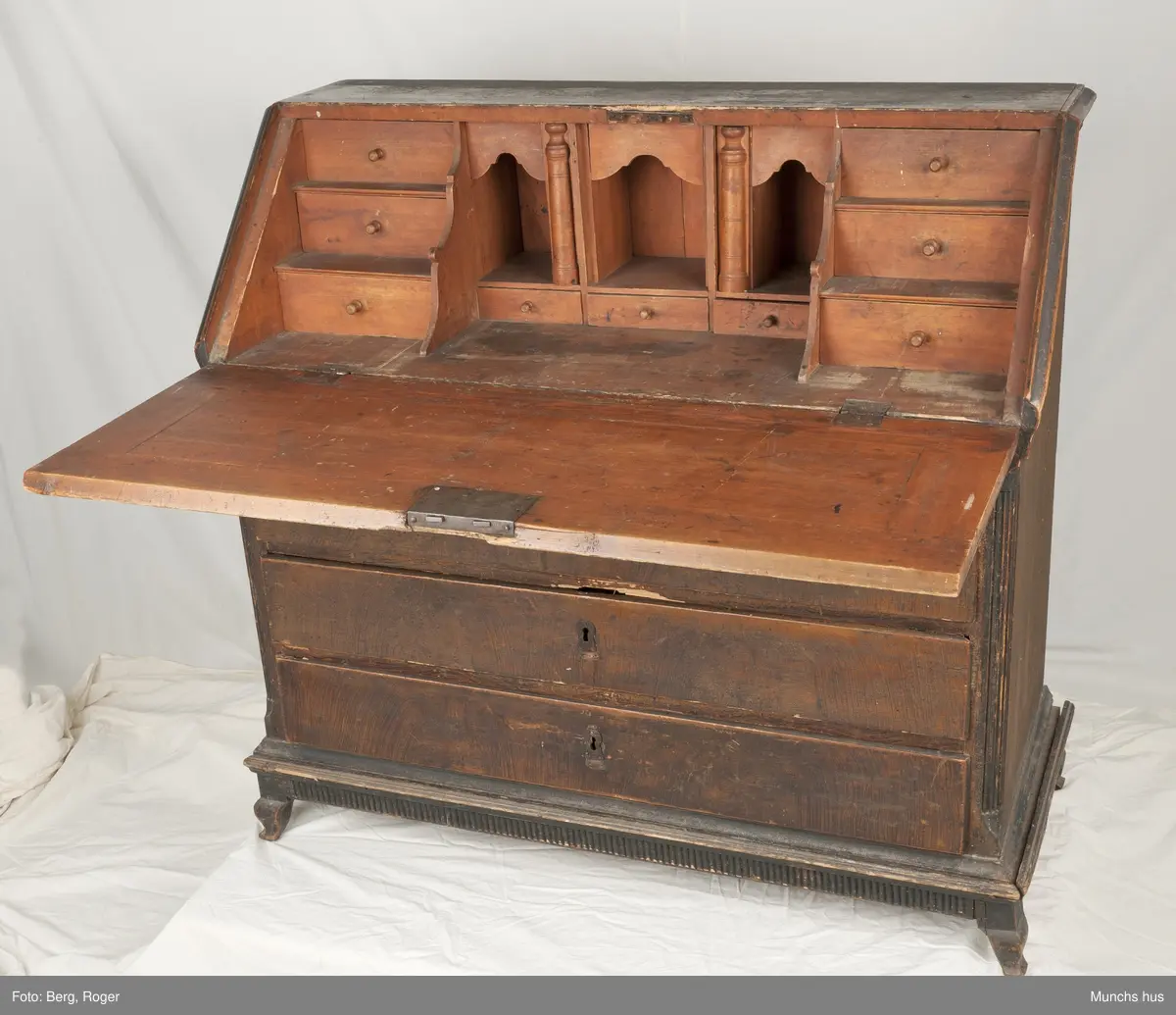 Et skatoll med 4 skuffer og sarg.  To speil i klaffen ni små skuffer inni og tre rom.