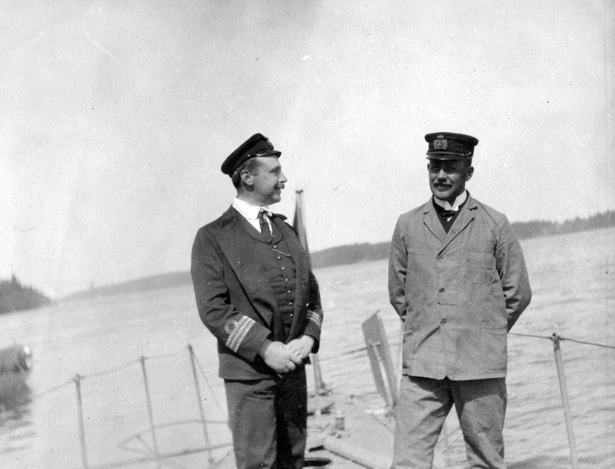 Två herrar konverserar på fartygdäck 1911.