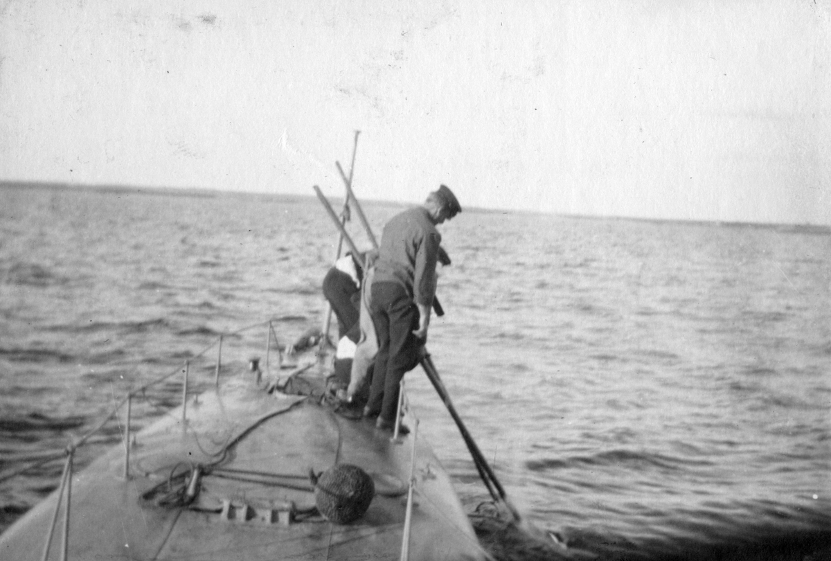 Matroser på ubåt i fart med att bogsera in en skjuten torped, Karlskrona 1914-1915.