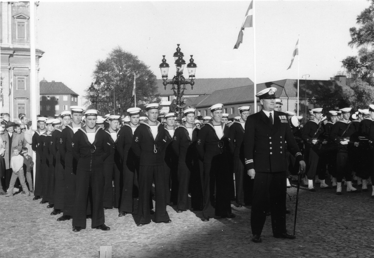 Bilden visar flera grupper av sjömän som har tagit uppställning framför Fredrikskyrkan i Karlskrona.