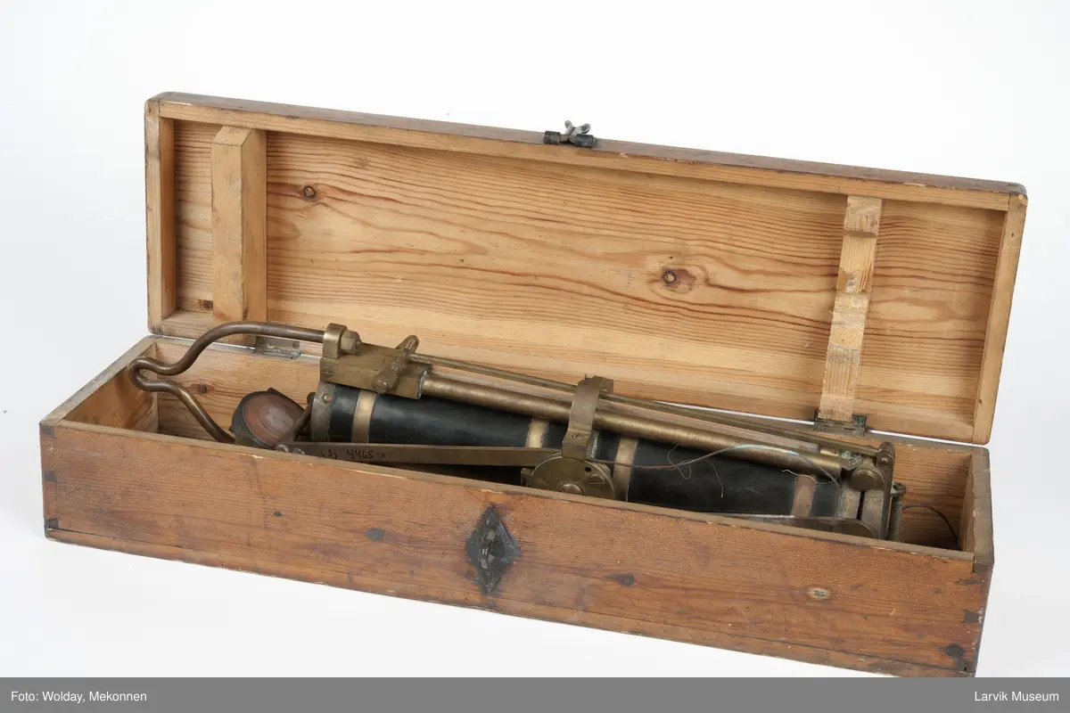 Prøvetakingsinstrument for henting av vannprøver fra havdyp, såkalt "Nansenflaske. I originalt treetui m/håndtak, Celluloidsylinder m. beslag og detaljer i messing. Mekanisme på siden til å lukke lokkene, et i hver ende av sylinderen. Oppheng til wire. Etui.
Form: Sylinder