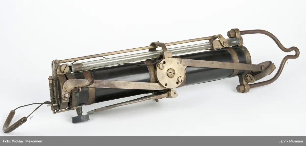 Prøvetakingsinstrument for henting av vannprøver fra havdyp, såkalt "Nansenflaske. I originalt treetui m/håndtak, Celluloidsylinder m. beslag og detaljer i messing. Mekanisme på siden til å lukke lokkene, et i hver ende av sylinderen. Oppheng til wire. Etui.
Form: Sylinder