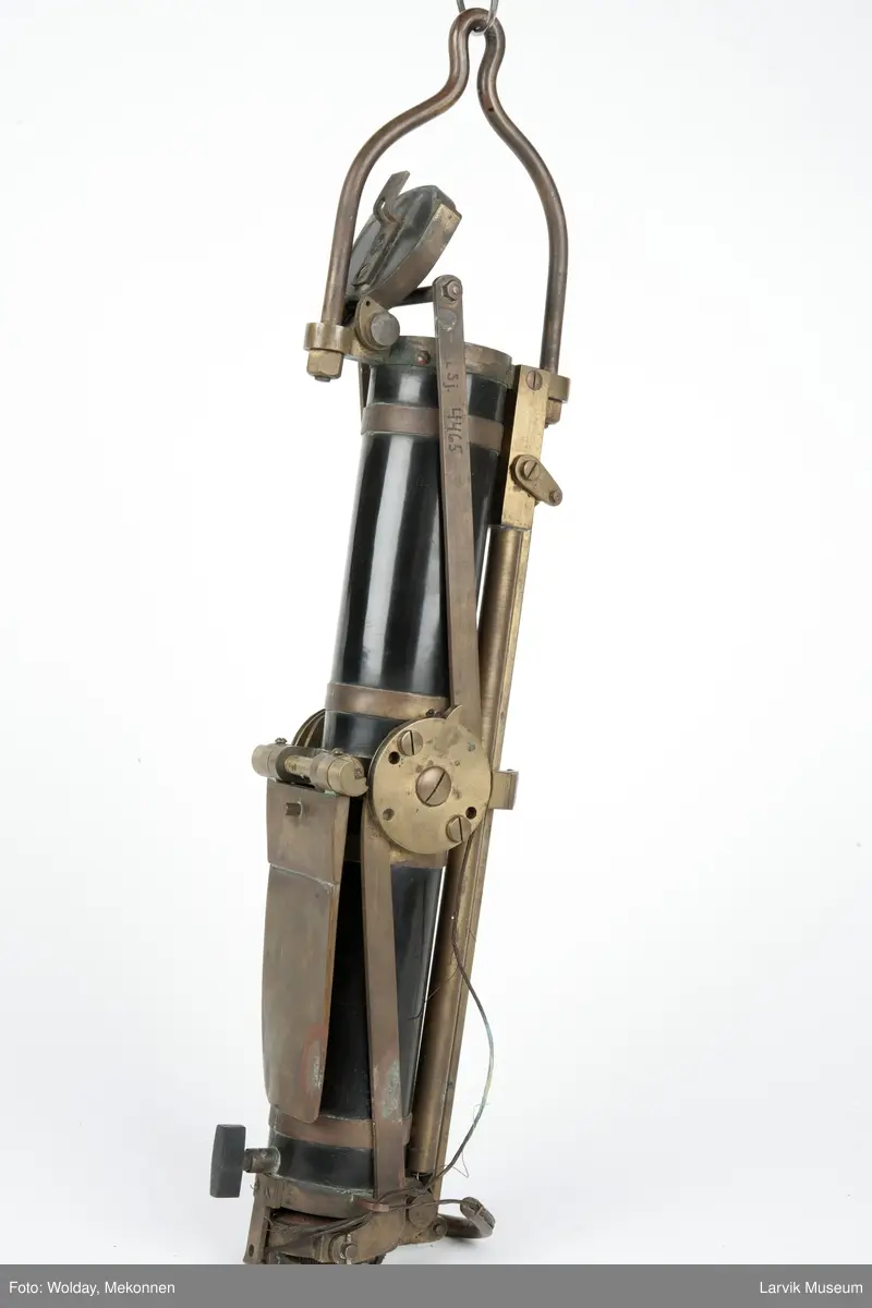 Prøvetakingsinstrument for henting av vannprøver fra havdyp, såkalt "Nansenflaske. I originalt treetui m/håndtak, Celluloidsylinder m. beslag og detaljer i messing. Mekanisme på siden til å lukke lokkene, et i hver ende av sylinderen. Oppheng til wire. Etui.
Form: Sylinder