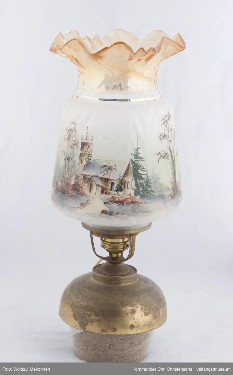 Oljelampe. Glass, blåst i form. Påmalt landskap med kirkebygning og hus. Topp er farget brunlig.
