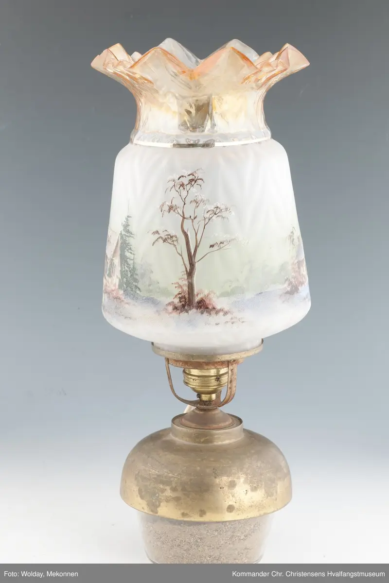 Oljelampe. Glass, blåst i form. Påmalt landskap med kirkebygning og hus. Topp er farget brunlig.