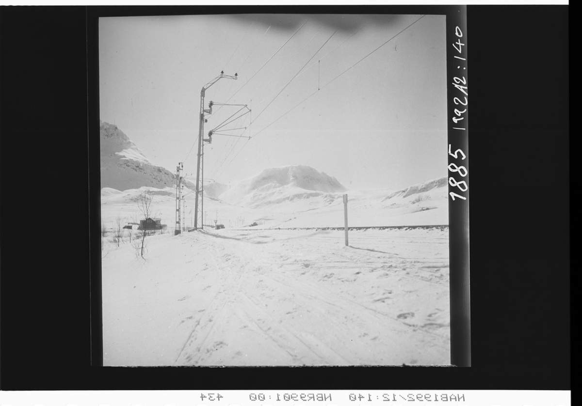 Katterjåkk holdeplass med Appelsindalen bak og Vassitjokka er fjellet bak til venstre.
Elektrifisert jernbane.