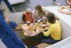 Familj dricker kaffe i sittbrunnen på en Albin 25. Marknadsföringsbild.