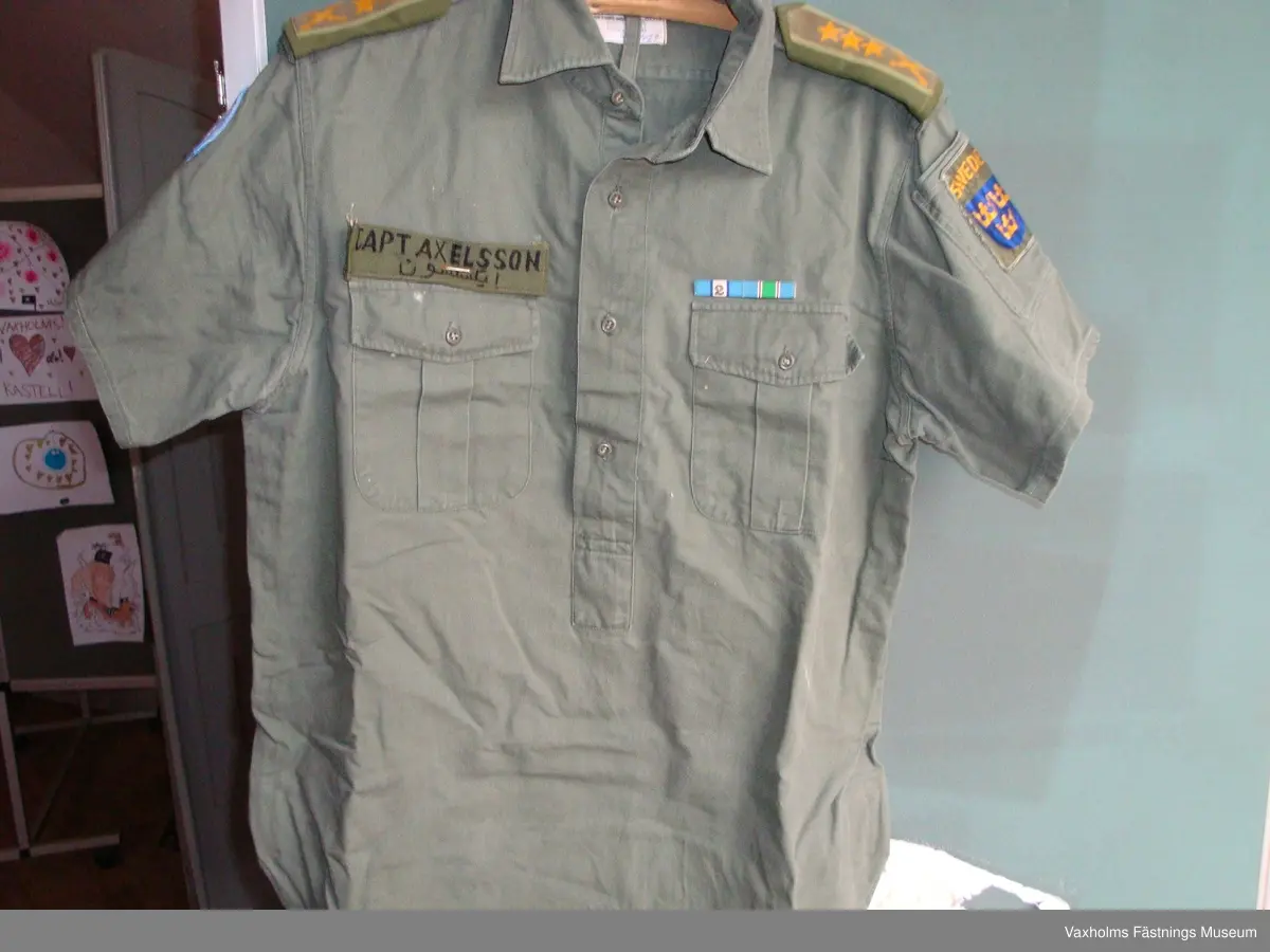 Uniform FN grön indisk modell,  skjorta med kort ärm och byxor. Blå fältmössa och blå halsduk.