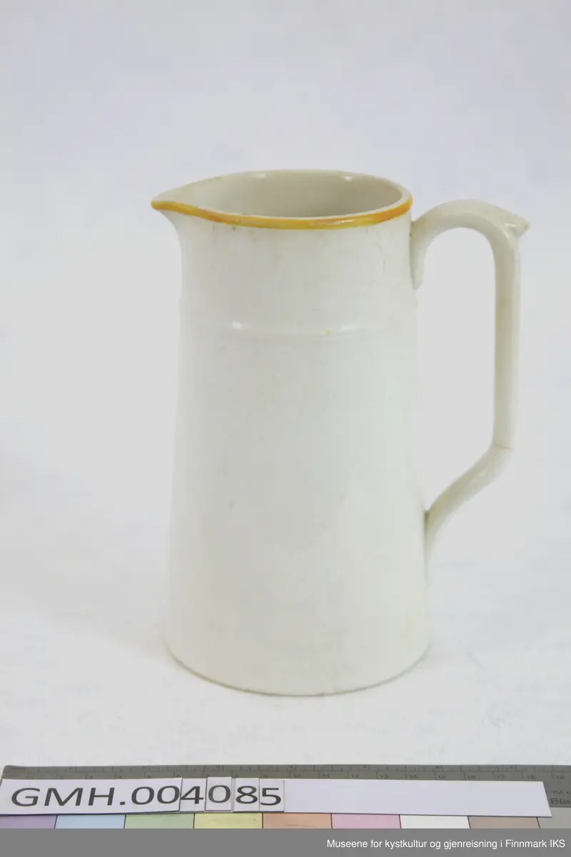 Muggen er utført i porselen med gule detaljer. Framsiden av muggen er dekorert med de ornamenterte bokstavene SB og en malt dekorasjonskant øverst. Muggen har en konisk form og på øvre del finnes en horisontal stav som dekorativt element. Håndtaket, som også har en malt dekorasjon, har en dyptgående sprekk i nedre del.