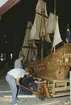 Modellen av Vasa i skala 1:10 justeras på plats i Vasamuseet. Stående Stefan Bruhn och Lars Thorhagen. Knäböjd Göran Forss.