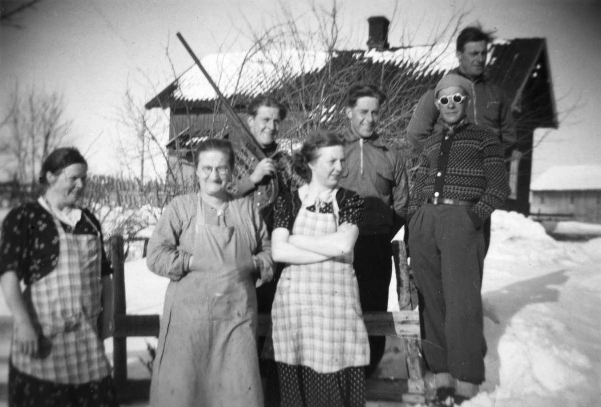 Gruppe 7. Bilde tatt utenfor "Nystua" tilhørende småbruket Myre i Ottestad, Stange. Bilde er tatt på midten av 1930-tallet. Tømmerstua ble revet i 1951. Fra venstre: Martha Dahlø, Berte Myhre, Trygve Myhre, Tilla Myhre, Håkon Holen, Anders Myhre og Ottar Myhre.