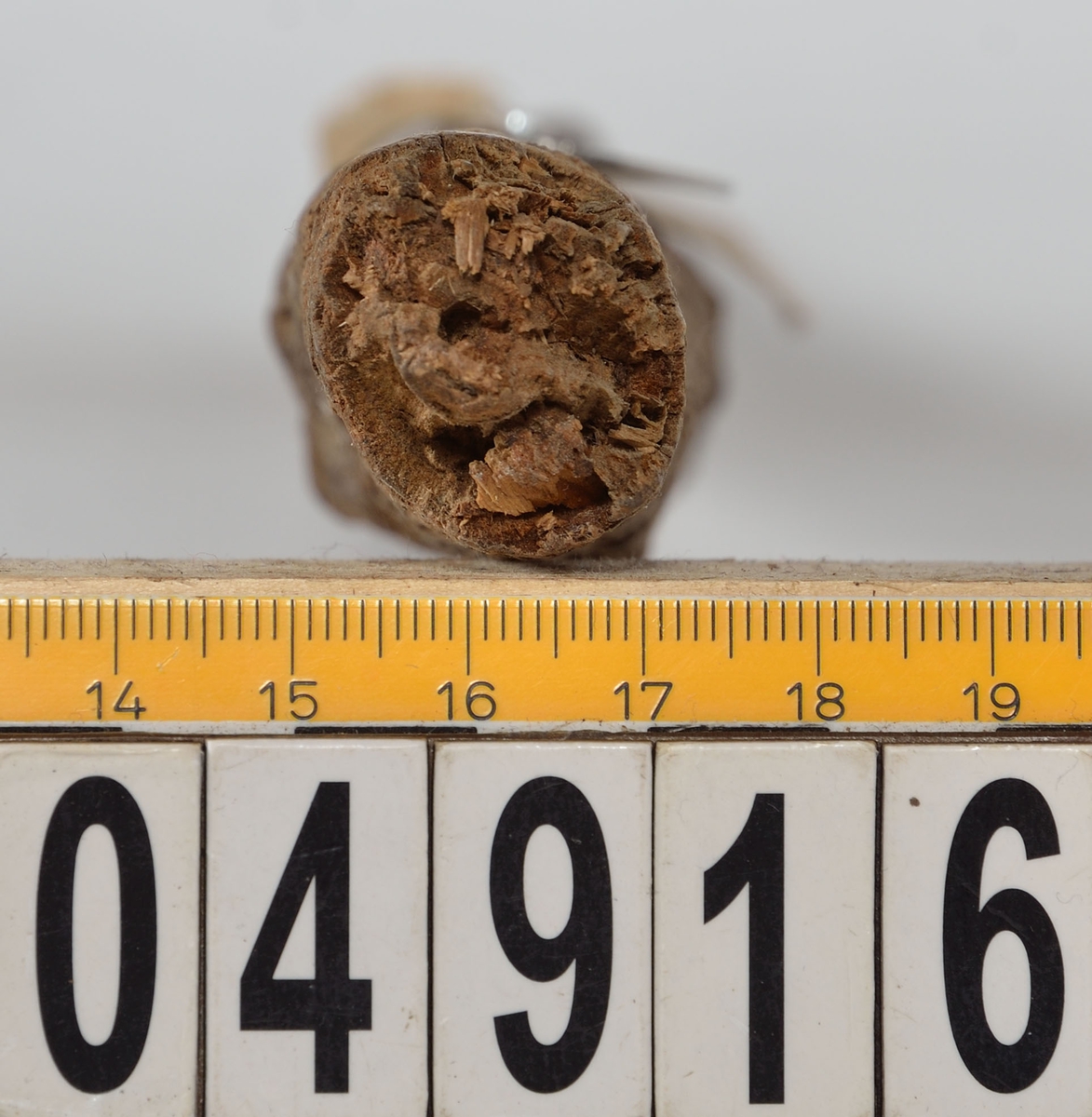 Skaft till laddredskap. Om det handlar om en ansättare, viskare eller laddskyffel går inte att säga. Mycket anfrätt utom på en sträcka av 135 mm från den tjocka änden där en kolv har suttit. I denna ände sitter det en flat kil kvar som har fixerat nämnda kolv. Den andra änden är avbruten.