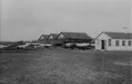 Exteriör av Enoch Thulins flygskola i Ljungbyhed år 1918. Framför hangarerna står från flygplan Thulin C (SW 12), Thulin B märkt med 'S', Thulin A och Thulin E. Längst till höger en administrationsbyggnad.