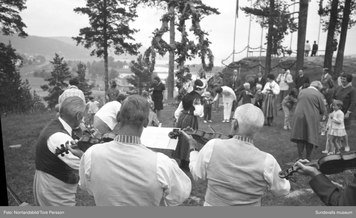 Midsommarfirande på Huberget i Stöde, med spelmän och dans kring midsommarstången.