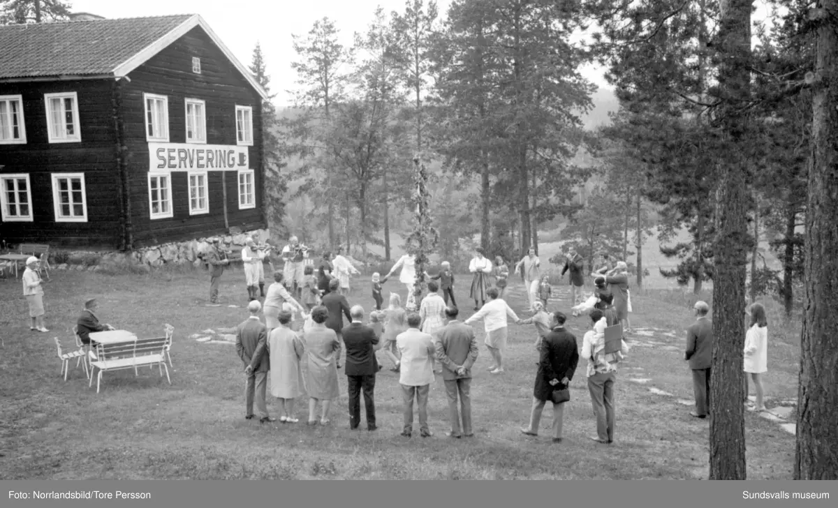 Midsommarfirande på Huberget i Stöde, med spelmän och dans kring midsommarstången.